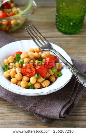 Chickpeas with tomatoes and onions on a plate, nutritious food