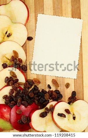 The page of the culinary book decorated with apples and raisin with a place of a copy for your record or page of a photograph album