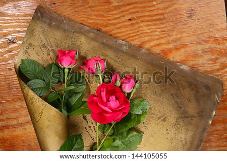 Art flower composition. Roses on brazen and wood background