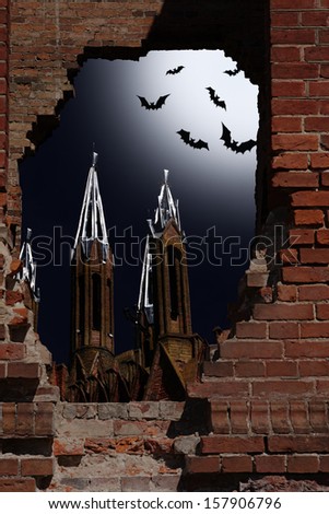 Halloween idea. Night kind through a hole in a wall upon the church and bats in the sky
