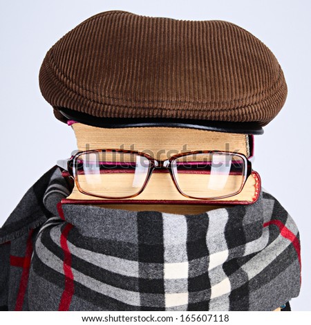 Burlesque of a writer of detective novels: books, eyeglasses, cap, a scarf