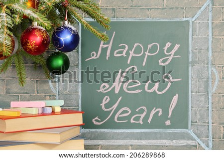 Books and Christmas decorations before chalkboard with title: Happy New Year!
