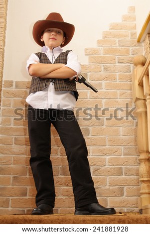 Boy as a cowboy posing with gun
