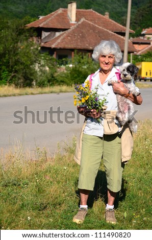 happy old woman with her dog in the mountain