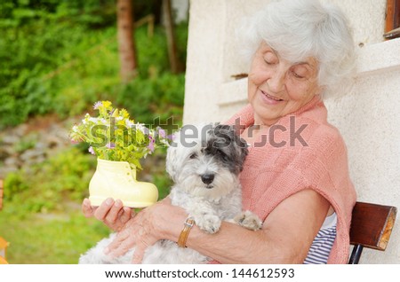 old woman hugging her dog smiling at the camera