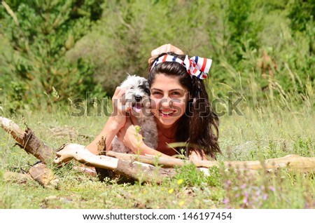 beautiful girl hugging her  little dog in the summer mountain