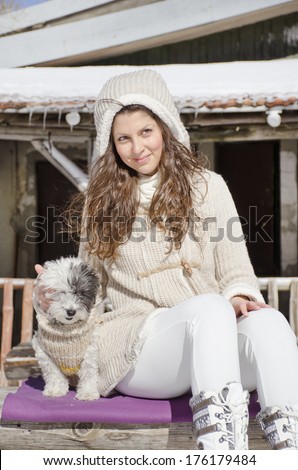 beautiful young woman enjoying the time spent with her dog in the winter  mountain