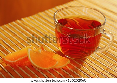 Cup of tea and fruit jelly on a bamboo table cloth still life