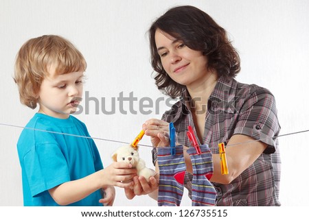 Mother with her little son hanging toy on a white background