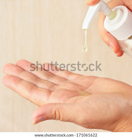 Female hands using cosmetic liquid soap close up