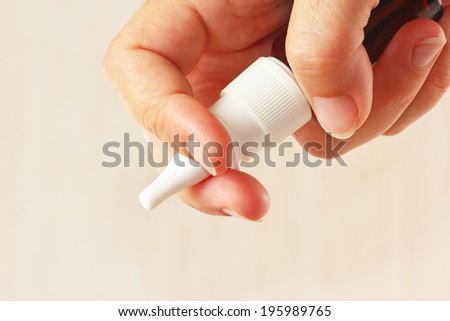 Female hand holding a nasal spray close up
