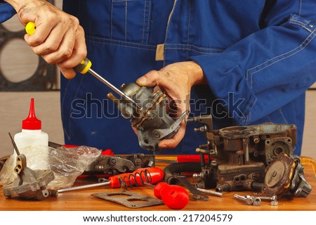 Mechanic repairing parts of the automotive engine in the workshop