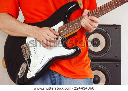Hands of musician playing the electric guitar closeup