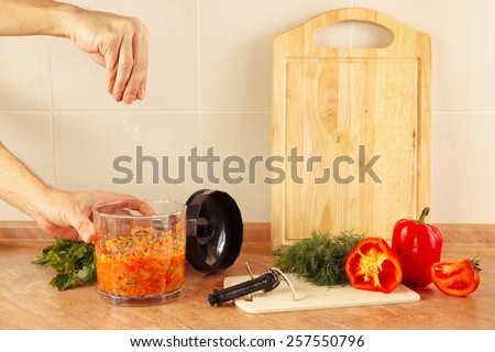 Hands of chef salt cooked vegetable mix in a blender