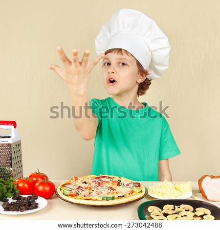 Little funny chef expressive enjoys a cooked pizza