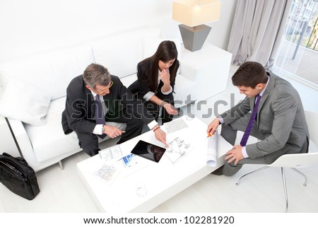 Business people at financial meeting with documents and tablet on table.