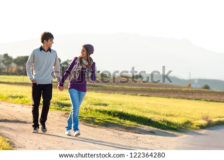 Young couple having a walk on dirt road in countryside