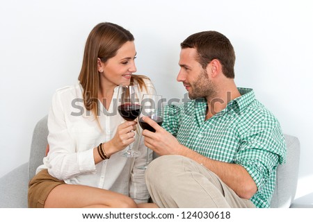 Close up portrait of cute couple making a toast with sparkling wine. Isolated on white.