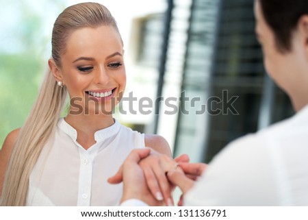 Close up portrait of cute girl being surprised with diamond ring on date.