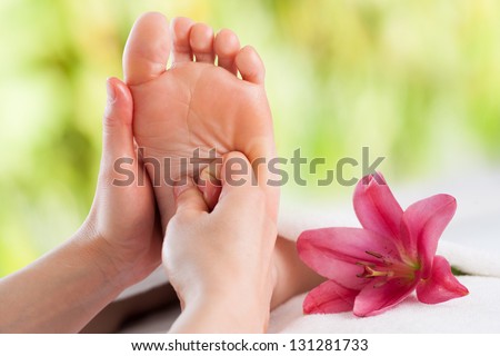 Macro close up of female hands massaging girls foot.