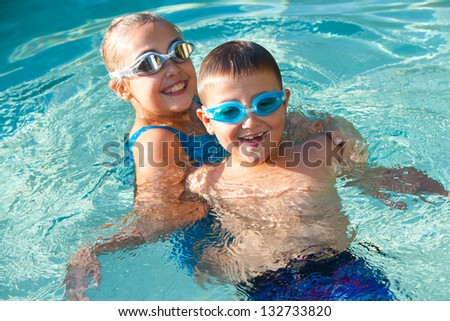 Kids having fun playing around in swimming pool.