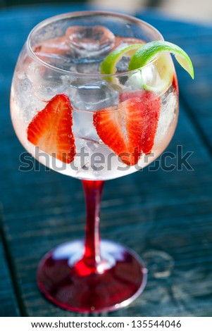 Close up of gin tonic cocktail with strawberries.