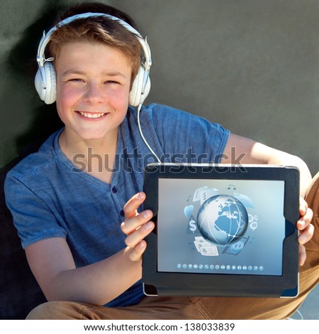 Close up portrait of boy with headphones holding tablet with multimedia symbols.
