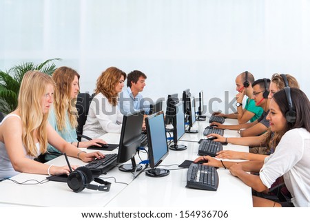 Group of young students doing training course on computers.