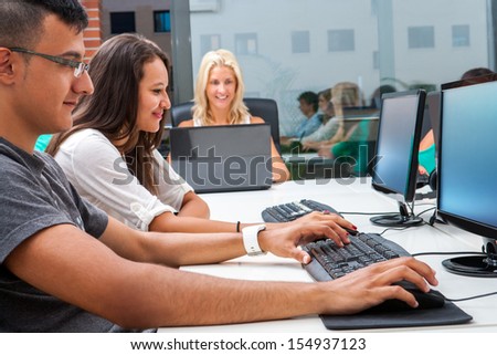 Group of young students doing training course on computers.