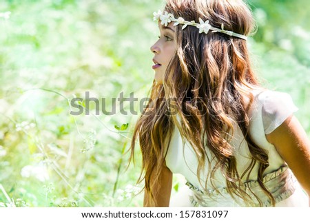 Close up portrait of cute girl in green field.