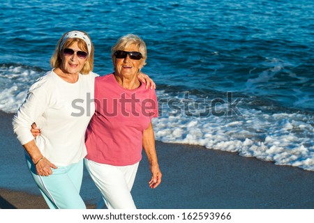 Portrait of two senior female friends in casual sportswear outdoors.
