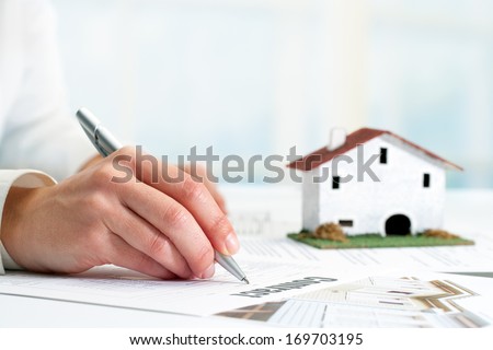 Extreme close up of female hand signing real estate contract.
