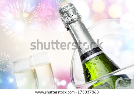Close up champagne bottle in ice bucket with festive colorful background.
