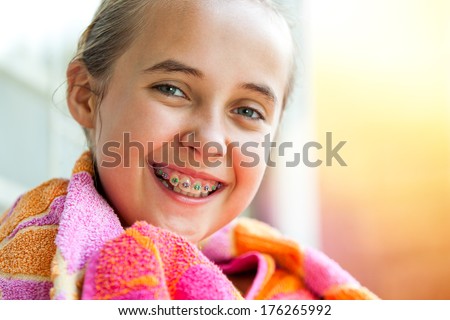 Close up outdoor portrait of cute kid with dental braces smiling.