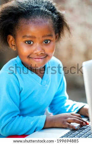 Portrait of young African student learning with laptop.