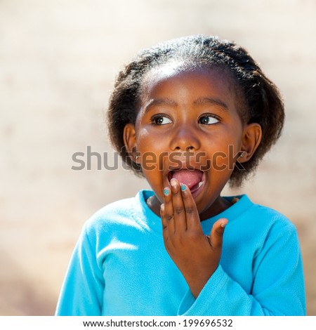 Close up portrait of little African girl with surprised face expression.