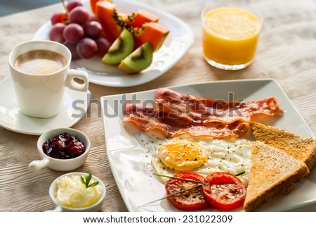Close up of english breakfast with fresh fruit and coffee.