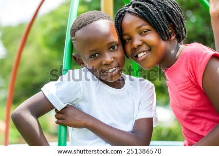 Close up face shot portrait of African kids joining heads in park.