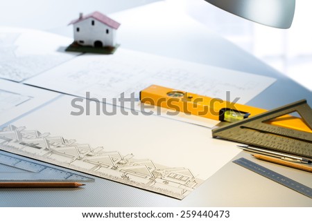 Detail of architect desk with technical drawings and measuring tools.