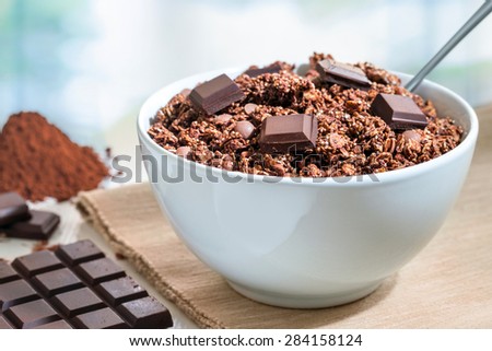 Extreme close up of Healthy muesli breakfast.Chocolate muesli with slab and cacao powder in background.