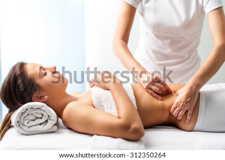 Close up of osteopath doing manipulative massage on female abdomen.