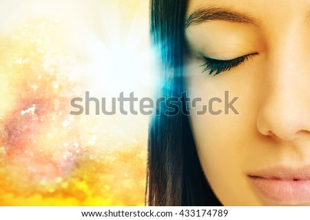 Macro close up of young woman meditating with eyes closed.Conceptual spiritual background with light beam.