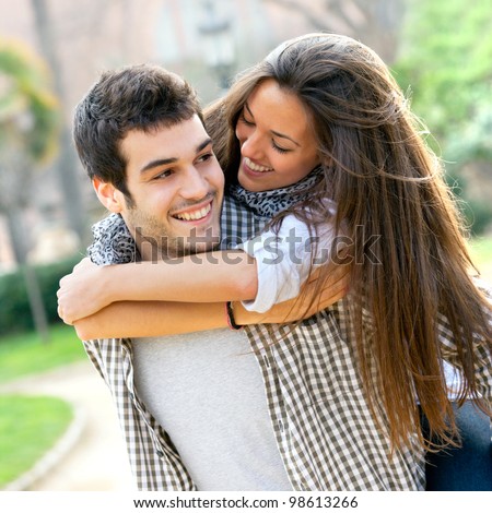 Close Up Portrait Of Attractive Young Couple Piggybacking Outdoors.