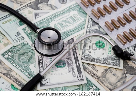stethoscope and pills and US money, concept of health care reform