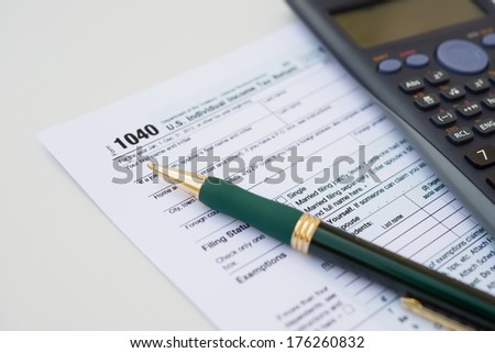 US Tax form 1040 with pen and calculator