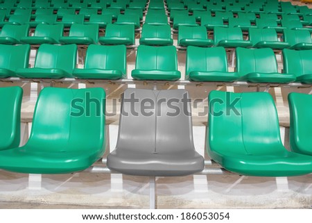 grey stadium seat between green seats