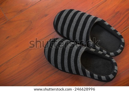 Pair of black shoes for man on wooden floor in bed room
