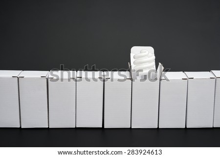 line of boxes with one open, an energy saving light bulb stands out