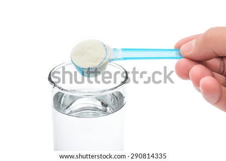 putting powdered milk into a glass cup with clipping path close up