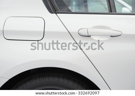 tire and petrol cap cover and door lock and window of a white car